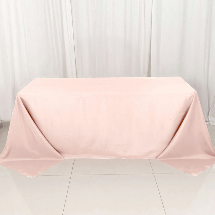 Pink tablecloth draped over a table on a white backdrop