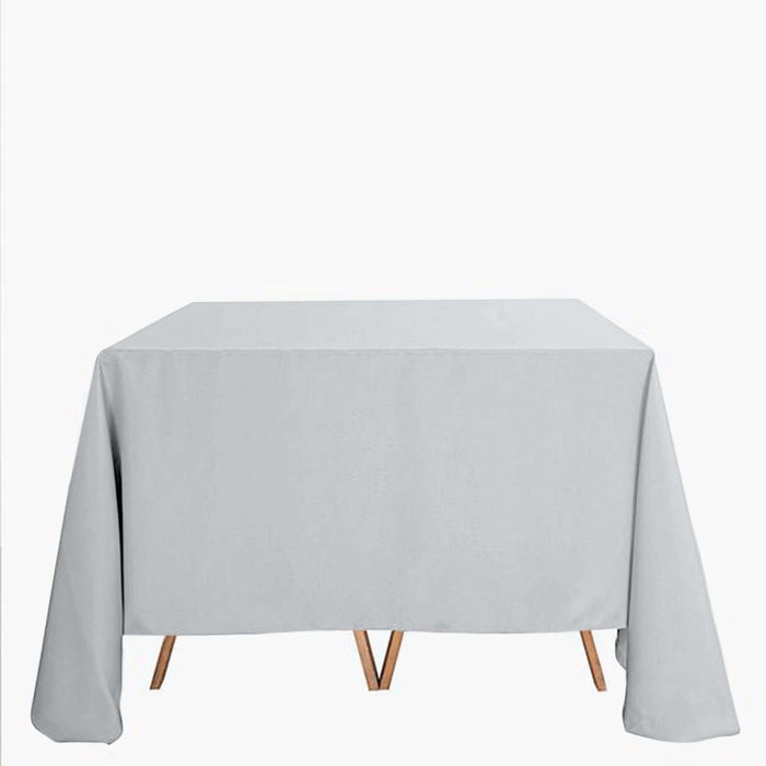 Gray tablecloth draped over a wooden table on a white background