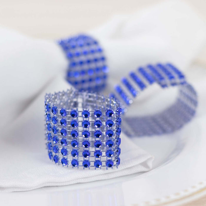 Blue crystal napkin rings elegantly displayed on a white table setting.