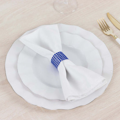 White napkin with blue rhinestone ring on a decorative plate.