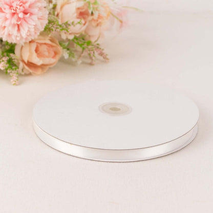 White ribbon spool on a plain background with floral accents