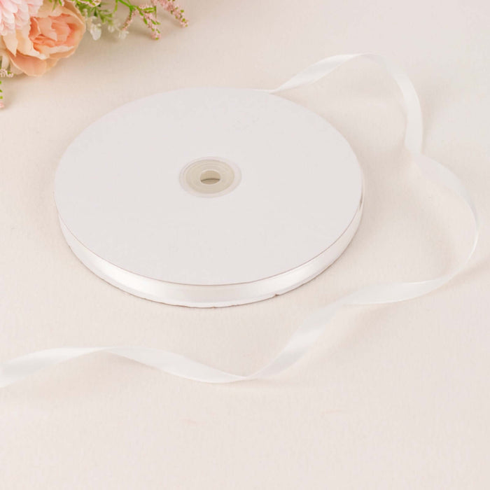 White satin ribbon roll with loose ribbon on a soft background.