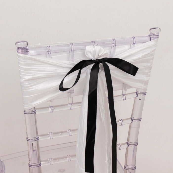 Clear acrylic chair with white and black satin ribbon decoration.
