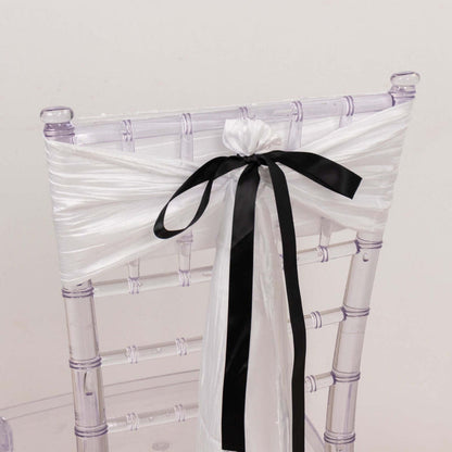 Clear acrylic chair with white and black satin ribbon decoration.