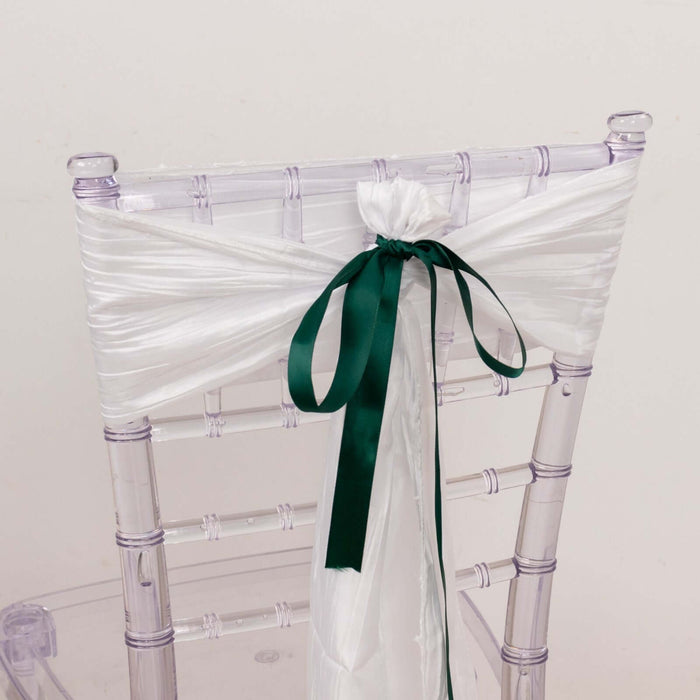 Clear chiavari chair with white satin ribbon and green bow.