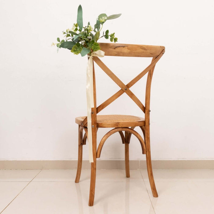 Wooden chair with floral arrangement and ribbon on the back