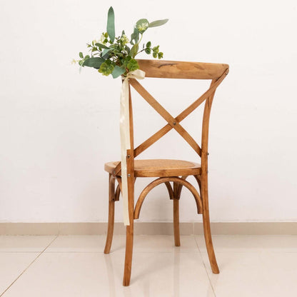 Wooden chair with floral arrangement and ribbon on the back