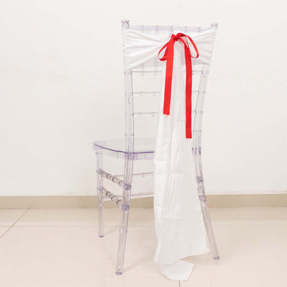 Clear chiavari chair with white draping and red ribbon accent