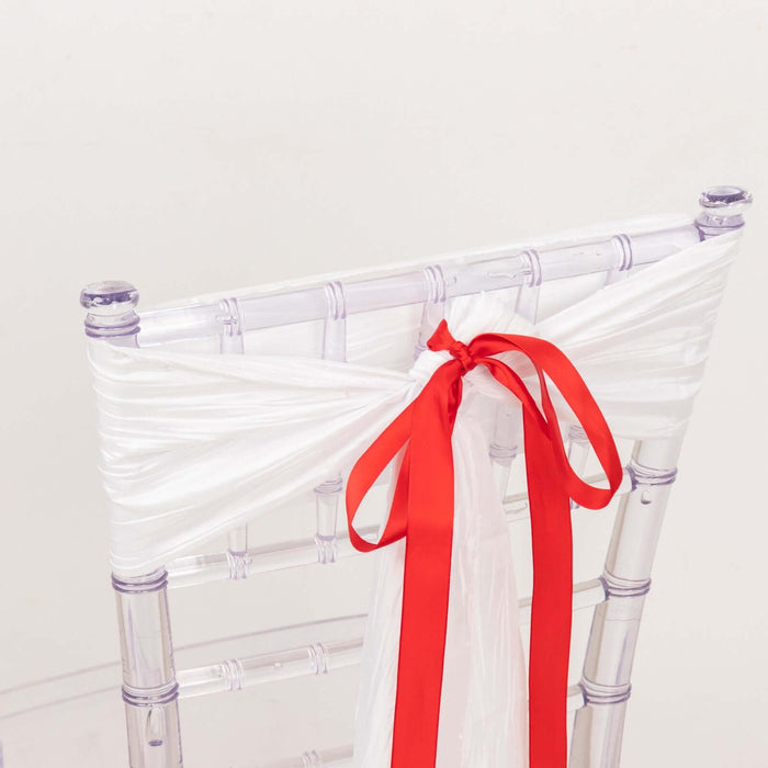 Transparent chiavari chair with white and red ribbon decoration.