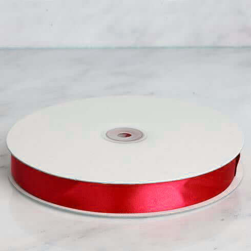 Red satin ribbon on a spool for crafting and decoration #whtbkgd