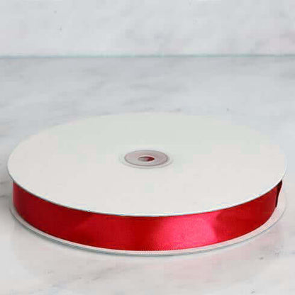 Red satin ribbon on a spool for crafting and decoration #whtbkgd