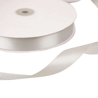 White satin ribbon on a spool with a loose end.
