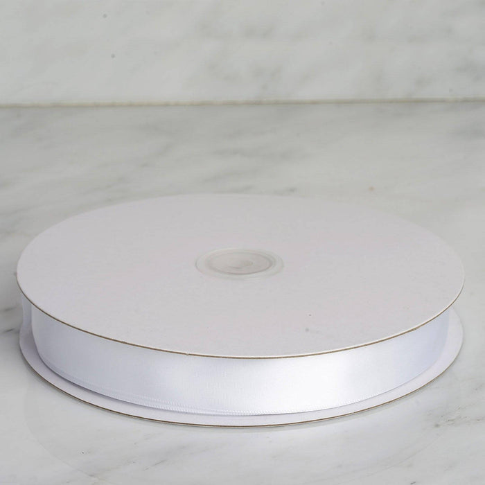 White satin ribbon on a spool against a marble background. #whtbkgd