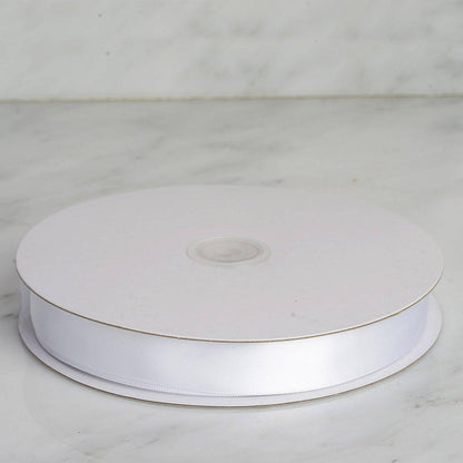 White satin ribbon on a spool against a marble background. #whtbkgd
