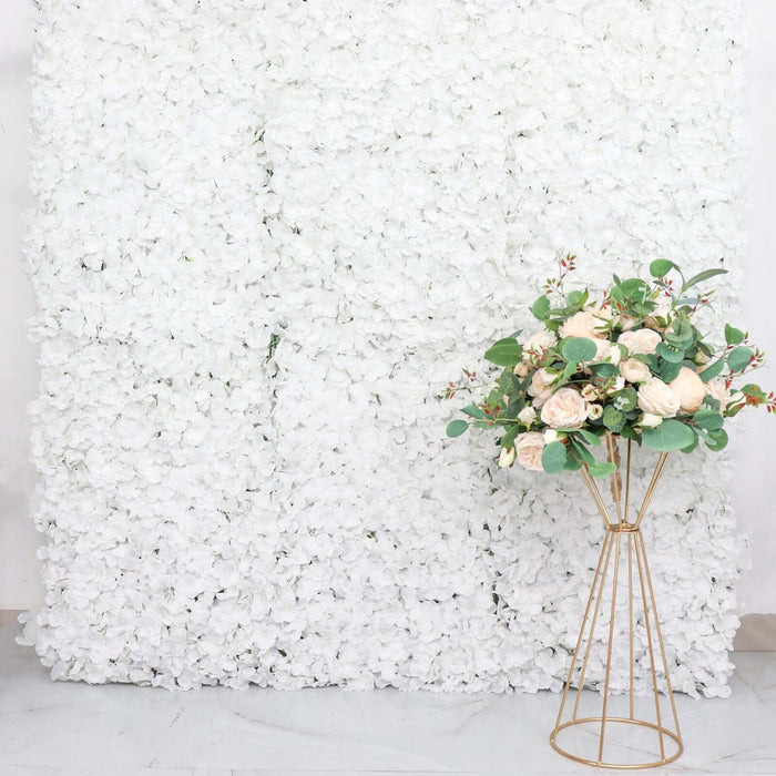 Floral arrangement in a gold vase against a white floral backdrop.