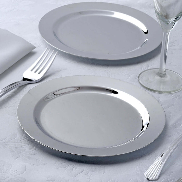 Two elegant silver plates on a textured tablecloth with cutlery.