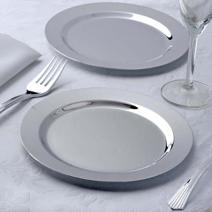 Two elegant silver plates on a textured tablecloth with cutlery.