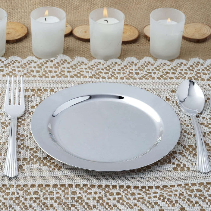 Silver serving plate with fork and spoon on a textured table setting.