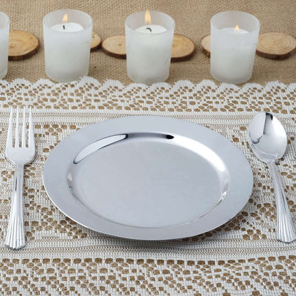 Silver serving plate with fork and spoon on a textured table setting.