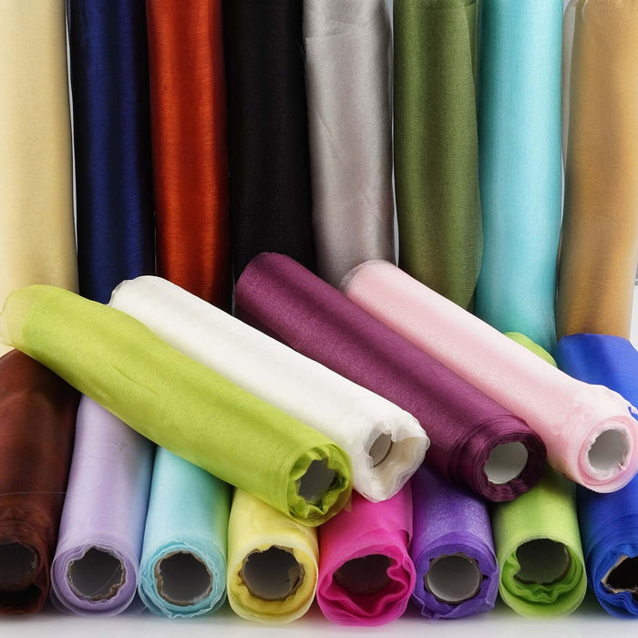 Colorful rolls of fabric in various shades stacked together.