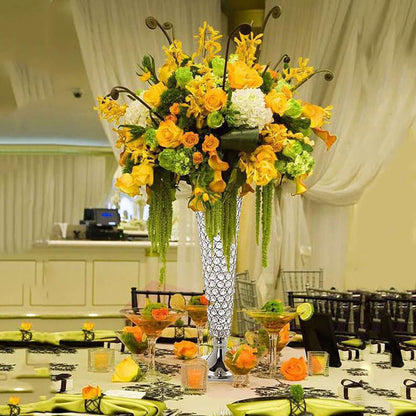 Elegant floral centerpiece with yellow and orange blooms in a tall vase.