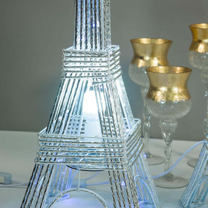 Eiffel Tower lamp with LED light and decorative candle holders in the background.