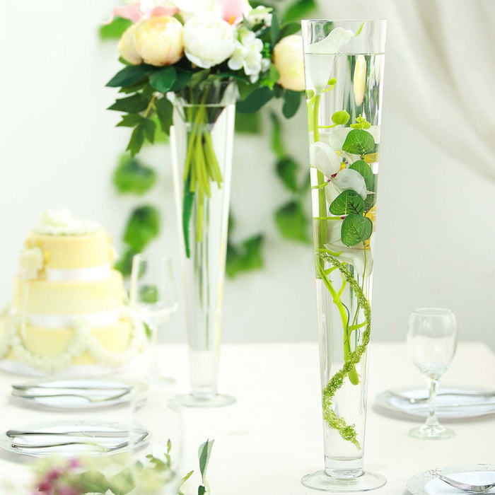 Elegant floral arrangements in tall vases for a wedding setting.