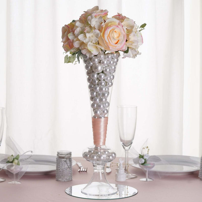 Elegant floral centerpiece with pearls in a glass vase for event decoration.