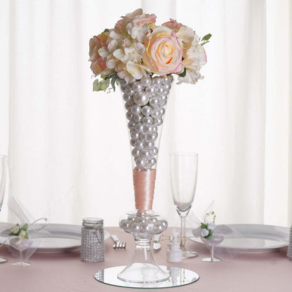 Elegant floral centerpiece with pearls in a glass vase for event decoration.