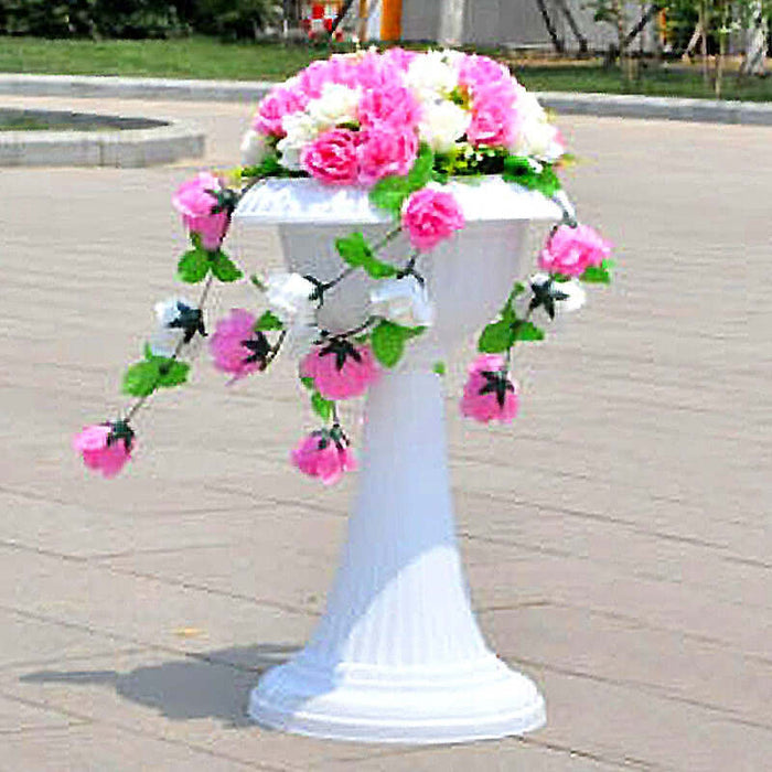White pedestal with floral arrangement featuring pink and white roses.