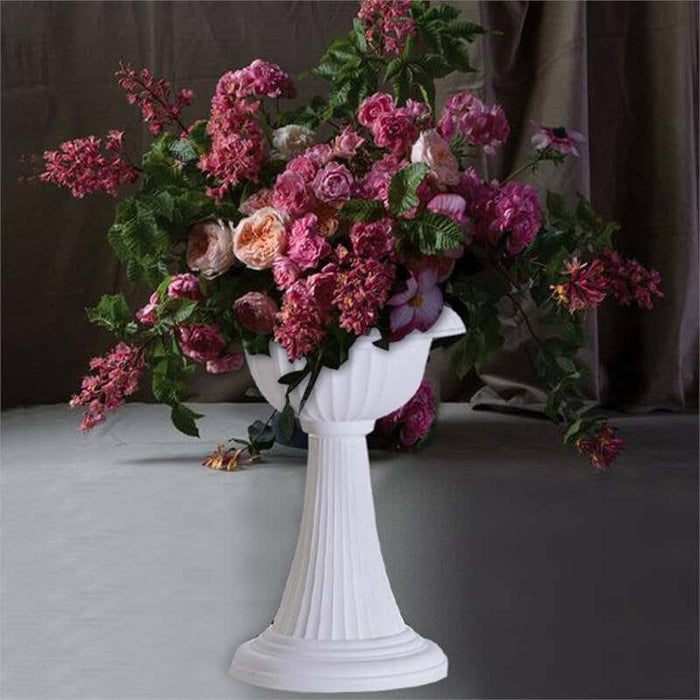 Elegant floral arrangement in a white pedestal vase.