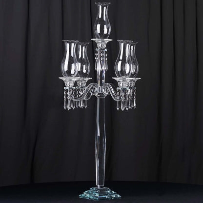 Elegant crystal candelabra with three glass shades on a dark background.