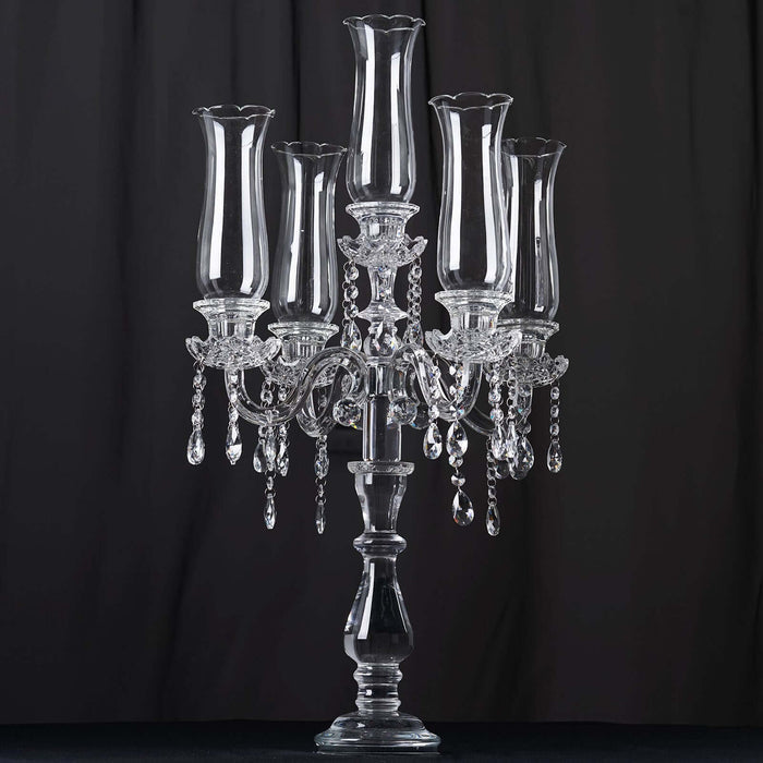 Elegant crystal candelabra with five candle holders and dangling beads.