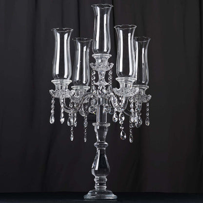 Elegant crystal candelabra with five candle holders and dangling beads.