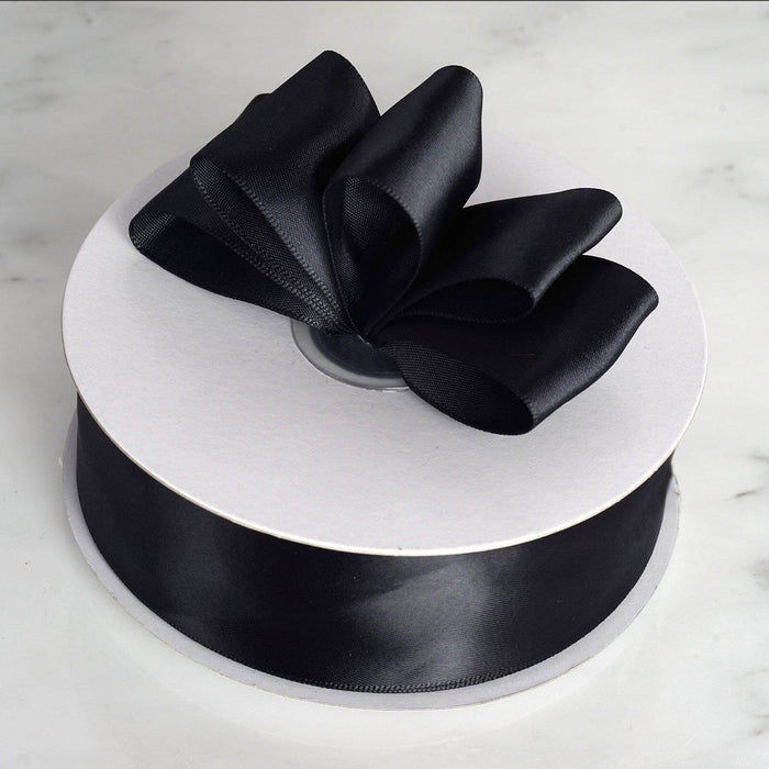 Black satin ribbon on a spool with a bow