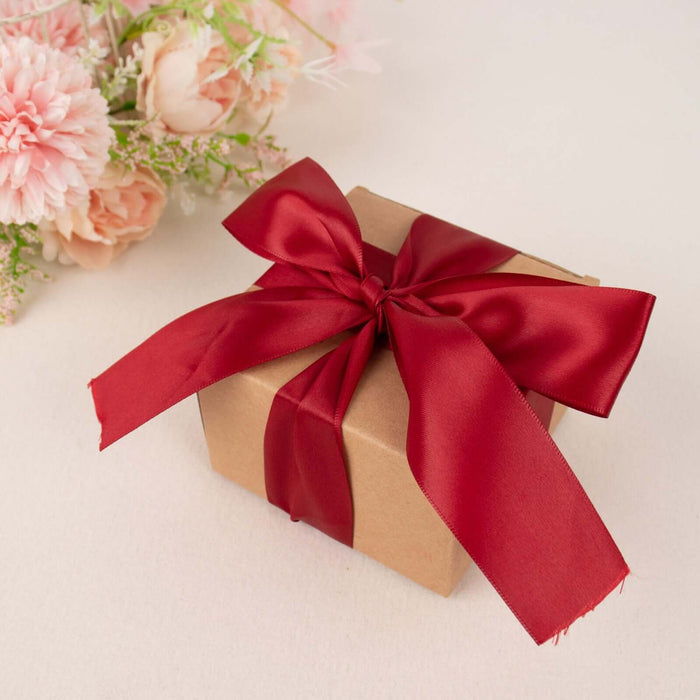Gift box with red ribbon on a soft background.