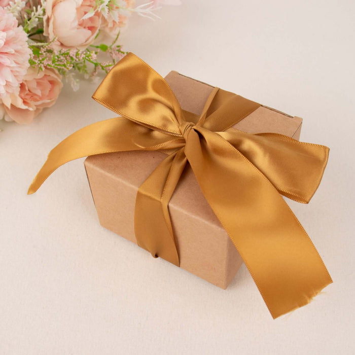 Brown gift box with a gold ribbon on a soft background.