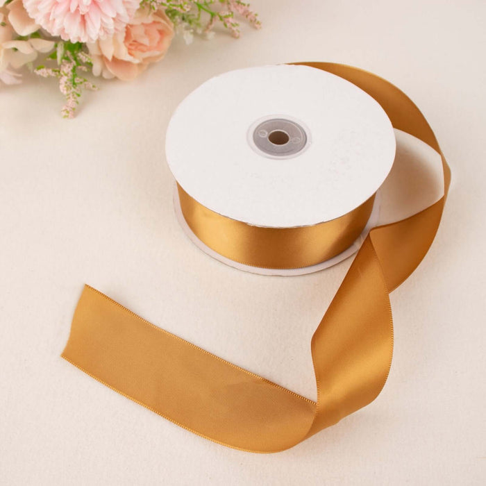 Gold satin ribbon on a roll with a loose end, ideal for crafting and decoration.