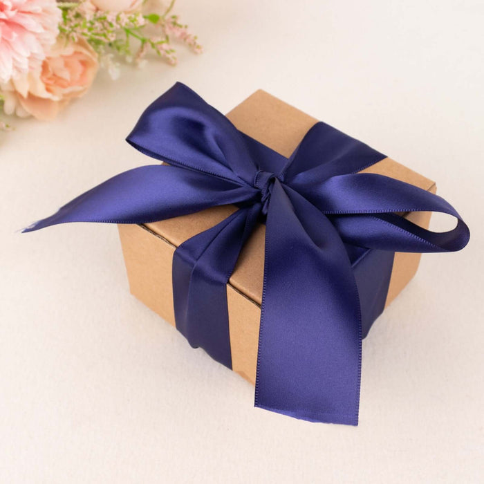 Brown gift box with navy ribbon on a soft surface.