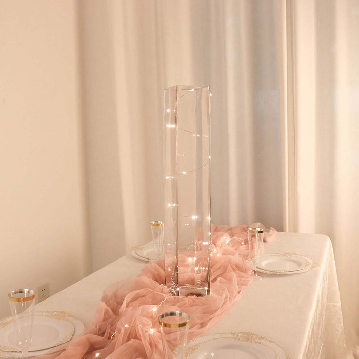 Elegant glass vase with fairy lights on a beautifully set dining table.