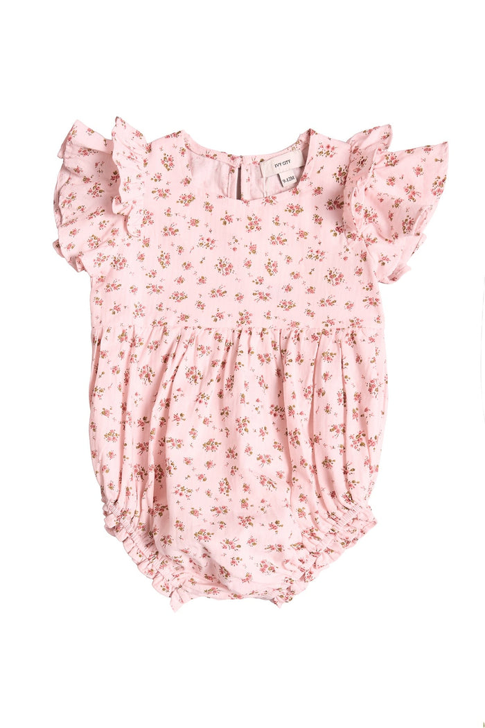Outfit your little one in the Ivy City Co Baby Hattie Romper in Madeline Pink, showcasing a sweet small floral print, short ruffled sleeves, and comfortable elastic leg openings. This romper features a soft, lightweight fabric ideal for warm days, along with a round neckline and softly gathered waist—making it a perfect pick for first birthday photos or bringing everyday charm to their wardrobe.