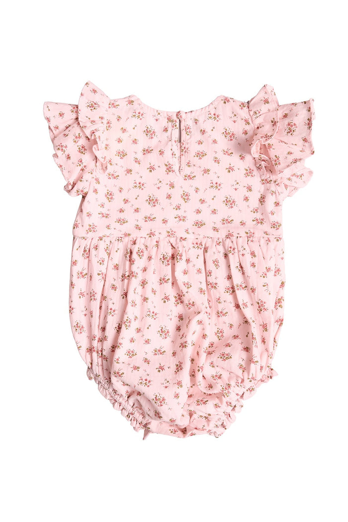 The Ivy City Co Baby Hattie Romper in Madeline Pink features ruffled sleeves, a delicate floral pattern, elastic leg openings, and a back button closure. Displayed on a white background, this sweet floral baby romper is perfect for your little one.