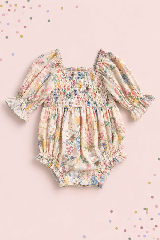 The Ivy City Co Baby Madeline Romper in Cordelia Floral features long puffed sleeves, ruffled cuffs, and a smocked bodice on pale pink with pastel confetti dots—perfect for adorable mommy-and-me moments.