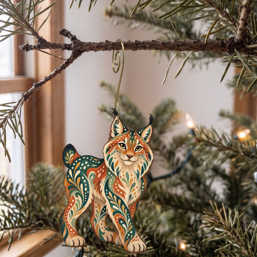 Laser-cut maple wood Canada Lynx folk art ornament O259 hanging on a fir branch, made in USA