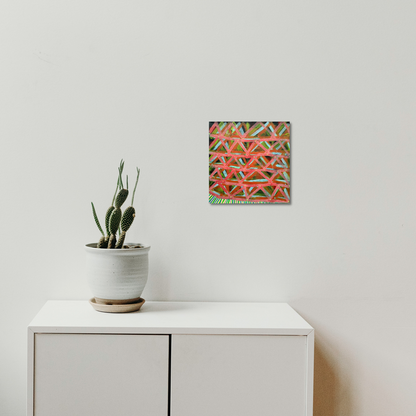 The artwork 'Composition No. 241' by Raul Ortiz features bold geometric triangular patterns in vibrant coral and green hues, creating dynamic intersecting lines on linen canvas. Mounted on a white wall above minimalist furniture with a decorative succulent plant, this 12x12 inch acrylic painting showcases a contemporary abstract design with precise linear composition.