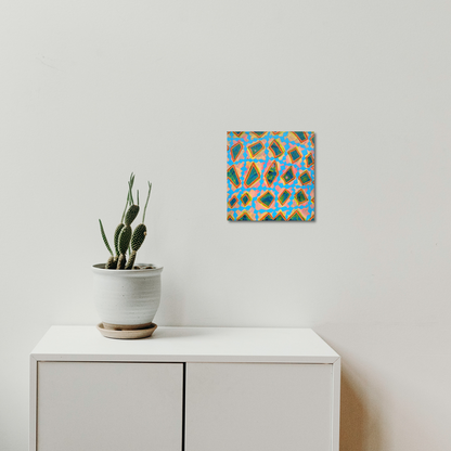 The artwork 'Composition No. 242' by Raul Ortiz features vibrant geometric patterns in turquoise blue and warm orange, creating a dynamic mosaic-like design on linen canvas. Abstract diamond shapes intersect and overlap in a repetitive pattern, displaying a modern minimalist aesthetic. The 12x12 inch acrylic painting hangs above a white cabinet beside a potted cactus.