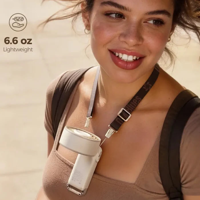 A woman outdoors wearing a Diveblues Portable High Speed Turbo Handheld Fan around her neck using the adjustable strap, with the text '6.6 oz Lightweight' in the upper left.