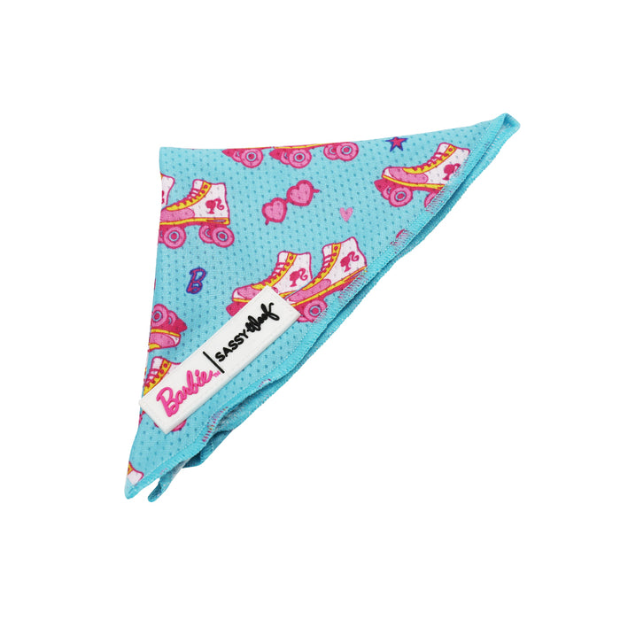The Sassy Woof Dog Bandana - BARBIE™ On a Roll features blue mesh fabric with pink and yellow roller skates, hearts, and B logos. Includes a white Barbie label—part of the Barbie x Sassy Woof collection.