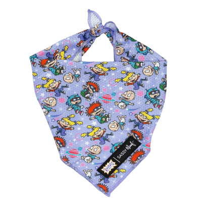 The Sassy Woof Dog Bandana - Nickelodeon Rugrats™ is a purple bandana featuring colorful Rugrats characters and a black Sassy Woof tag—perfect for fans of playful Nickelodeon dog accessories!.