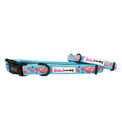 The Sassy Woof Dog Collar – BARBIE™ On a Roll features light blue color and colorful Barbie-themed designs with Barbie in a car, pink stars, and Barbie & Sassy Woof logos. It’s adjustable with a black buckle and sturdy metal ring.